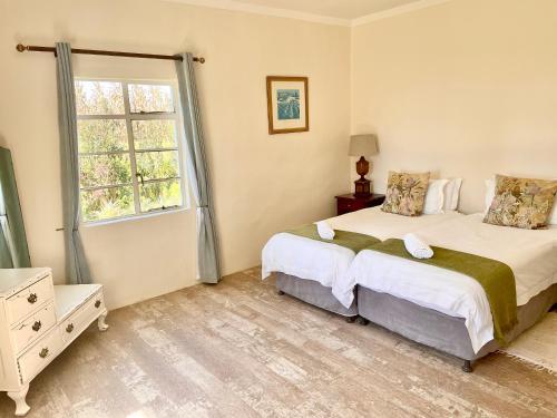 a bedroom with two beds and a window at Bellevue Berg Cottage in Bergville