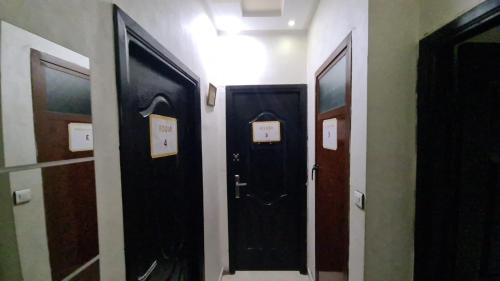 a hallway with two black doors in a room at Mohammed V Airport HOME in Deroua