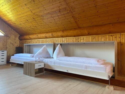 two beds in a room with wooden ceilings at Traumhaftes Blockhaus am Rhein in Kamp-Bornhofen