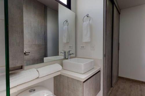 y baño con lavabo blanco y espejo. en Apartamento 601 kappadoccia, en Bogotá