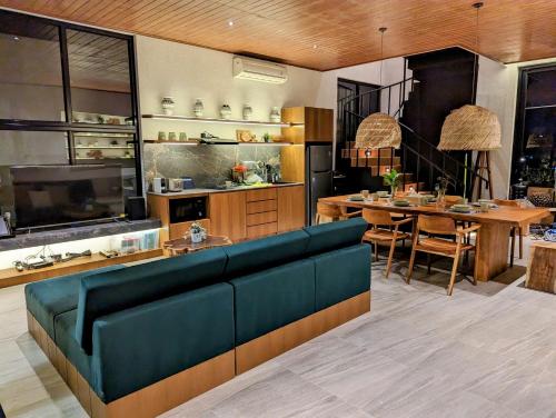 a living room with a couch and a dining room at Cottonwood Exclusive Villa Sagarmatha @Puncak in Bogor