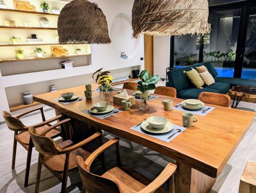- une salle à manger avec une table et des chaises en bois dans l'établissement Cottonwood Exclusive Villa Sagarmatha @Puncak, à Bogor