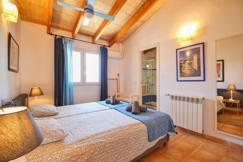 - une chambre avec un lit et une couverture bleue dans l'établissement Embat, à Colònia de Sant Pere