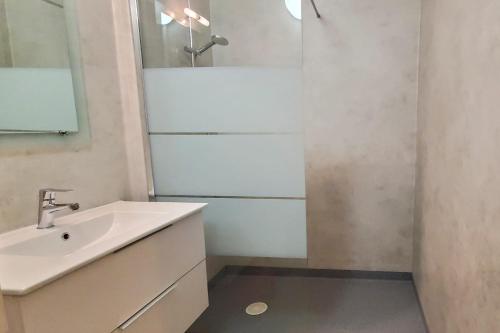 La salle de bains est pourvue d'un lavabo, d'un miroir et d'une douche. dans l'établissement Large studio in the center of town near the beach, à Saint-Aygulf