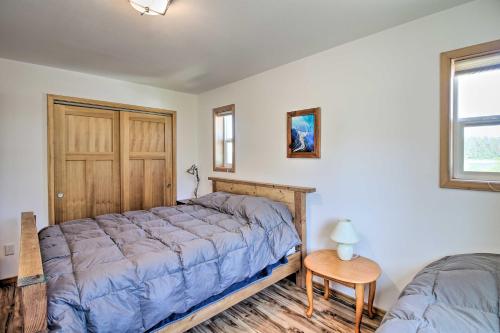 a bedroom with a bed and a table and a window at Waterfront Apt with Mtn View, Walk Into Town! in Craig