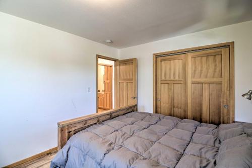 a bedroom with a large bed and a wooden door at Waterfront Apt with Mtn View, Walk Into Town! in Craig