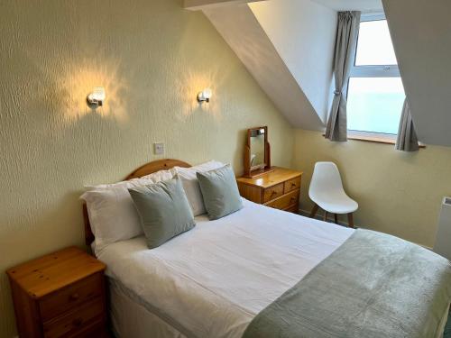 a bedroom with a large bed and a window at The Lookout in Ilfracombe