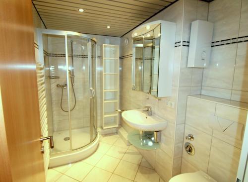 ein Bad mit einer Dusche, einem Waschbecken und einem WC in der Unterkunft Panorama Whg 92 in Cuxhaven