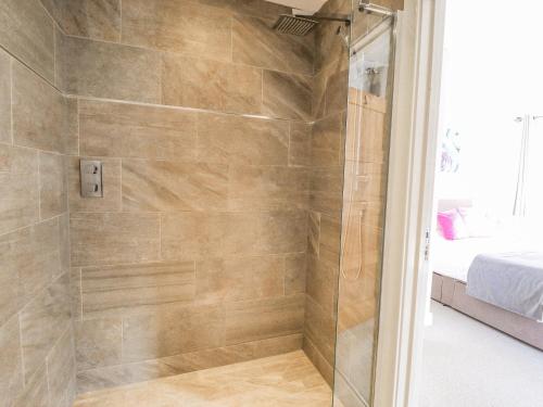 a shower with a glass door in a bathroom at Lily-pad Lodge in Thorpe on the Hill