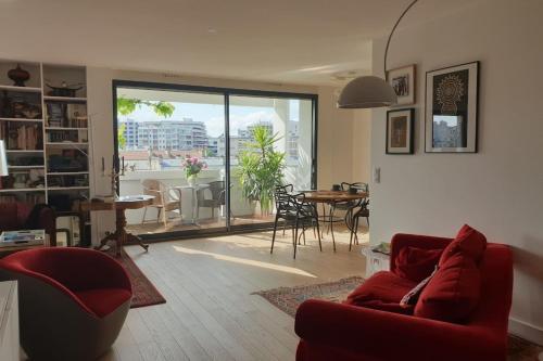 - un salon avec un canapé rouge et une salle à manger dans l'établissement Apt quiet and bright with large terrace, à Paris