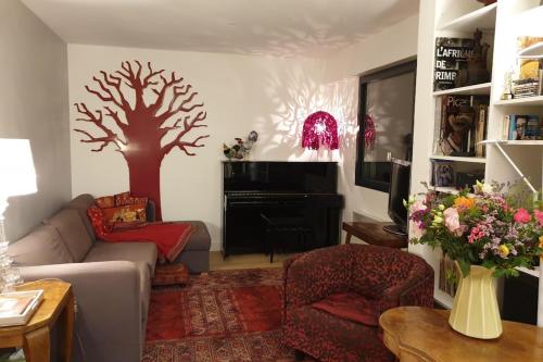 - un salon orné d'un arbre peint sur le mur dans l'établissement Apt quiet and bright with large terrace, à Paris