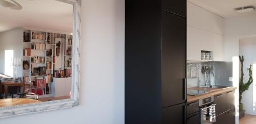 un miroir mural à côté de la cuisine dans l'établissement Apt quiet and bright with large terrace, à Paris