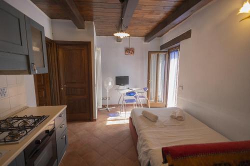 a room with a bed and a kitchen with a table at Residenza Audè in Monastero Bormida