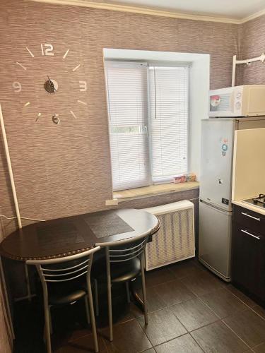 a kitchen with a table and a refrigerator at Апартаменты в самом Центре прПобеды 90 in Chernihiv