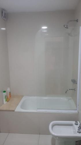 a white bathroom with a tub and a sink at BERSAGLIERE in Rosario