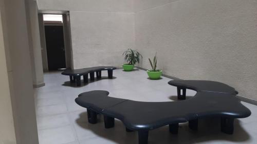 a hallway with three black benches in a room at BERSAGLIERE in Rosario