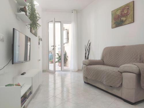 ein Wohnzimmer mit einem Sofa und einem TV in der Unterkunft Cla House in Assemini