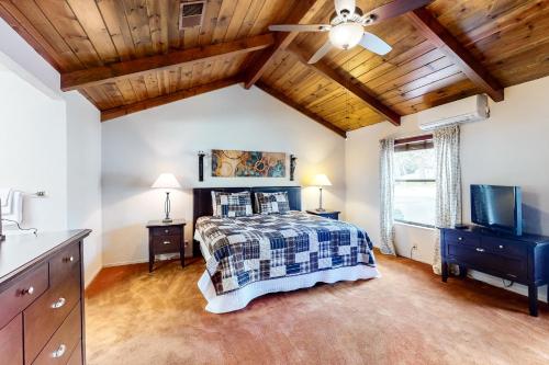 a bedroom with a bed and a wooden ceiling at Creekside Cabin in Groveland