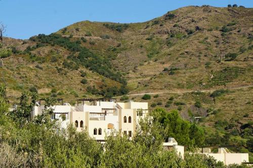 une maison blanche sur une colline avec une montagne dans l'établissement Lovely 1-Bed Apartment literally on the beach, à Cerbère