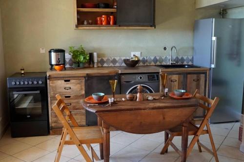 a kitchen with a table and chairs and a refrigerator at Lovely 1-Bed Apartment literally on the beach in Cerbère
