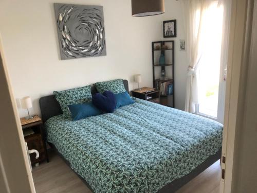 um quarto com uma cama com almofadas azuis em Capbreton hossegor chambre climatisée espace privé em Bénesse-Maremne