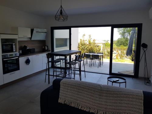 une cuisine et un salon avec une table et des chaises dans l'établissement Maisons T2 avec jardins privatifs - 10mn de la plage et 5mn du village - Casa di i trinelli, à Vescovato