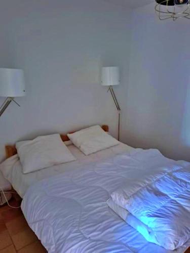 a white bed with a blue light on it at Vakantie Woning Le Chat Maison 175 in Écuras