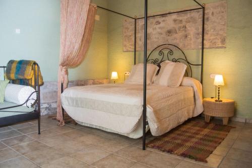 een slaapkamer met een groot bed met een baldakijn bij La Festa dels Sentits in Sant Martí de Maldá