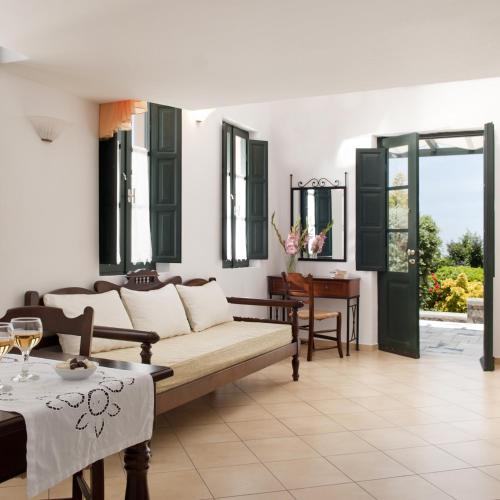 ein Wohnzimmer mit Sofa und Tisch in der Unterkunft Anthonas Apartments in Imerovigli