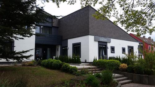 a white building with a black roof at APPART-HOTEL, Einsteinstraße in Herzogenaurach