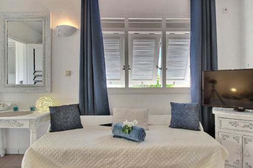 1 dormitorio con 2 camas, TV y espejo en Ty Paradis Magnifique Lodge pour un couple, en Sainte-Anne