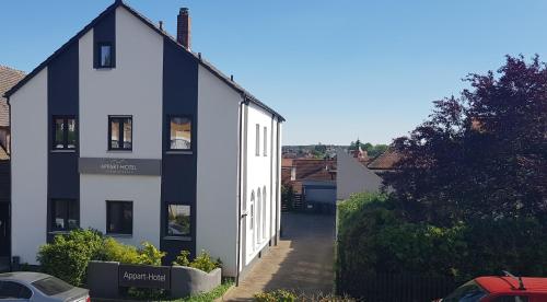 a white and black house with a driveway at APPART-HOTEL, Einsteinstraße in Herzogenaurach