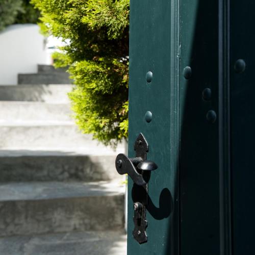 eine grüne Tür mit einem Türknauf aus Metall in der Unterkunft Anthonas Apartments in Imerovigli