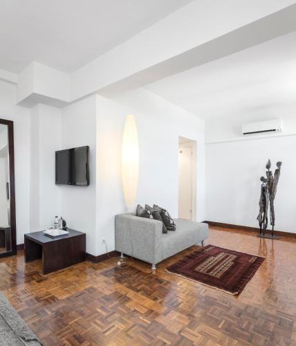a living room with a couch and a tv at Hotel Tivoli Beira in Beira