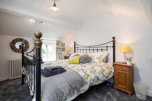 1 dormitorio con cama y mesita de noche de madera en Red Robin Cottage en Gaerwen
