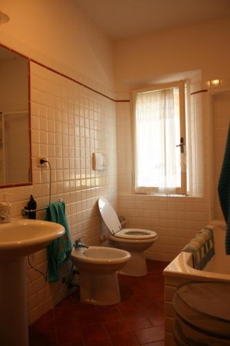 a bathroom with a toilet and a sink at Casa Rosada in Lucignano