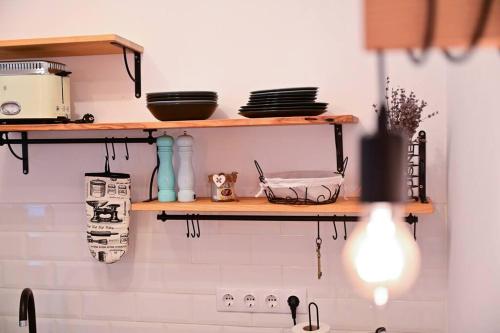 a kitchen with wooden shelves on the wall at FLH - Zen Apartment in Sibiu