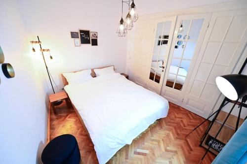 a small bedroom with a white bed in it at FLH - Zen Apartment in Sibiu