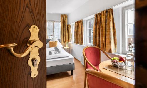 a room with a bedroom with a bed and a table at Hotel Sonnenstube Hagnau in Hagnau