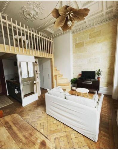 een woonkamer met een witte bank en een plafond bij Appartement gare Saint jean in Bordeaux