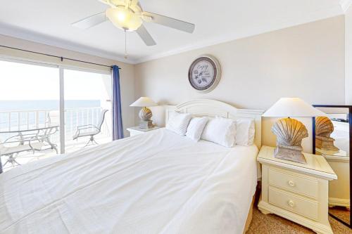 1 dormitorio con cama blanca y balcón en Ocean House II 2602, en Gulf Shores