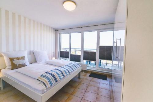 ein Schlafzimmer mit einem Bett und einem großen Fenster in der Unterkunft Haus am Waldbad AW15 in Cuxhaven