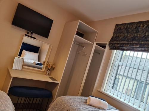 a small bedroom with a bed and a window at The Manor Guest Accommodation Dungiven in Dungiven