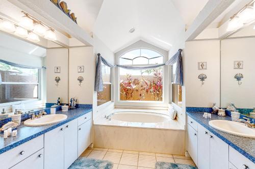 een badkamer met 2 wastafels en een groot bad bij Life at the Canal in Cape Coral