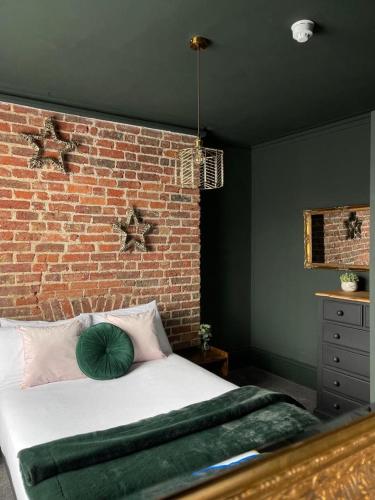 a bedroom with a brick wall and a bed at Salt Life One Bedroom Apartment in Brighton & Hove