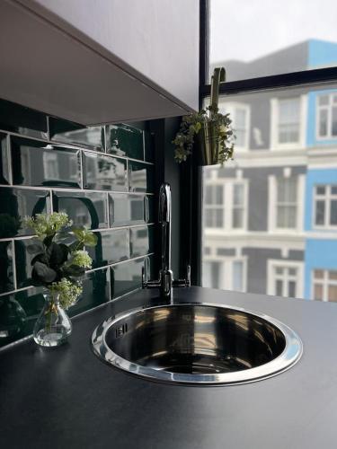a sink in a bathroom with a window at Salt Life One Bedroom Apartment in Brighton & Hove