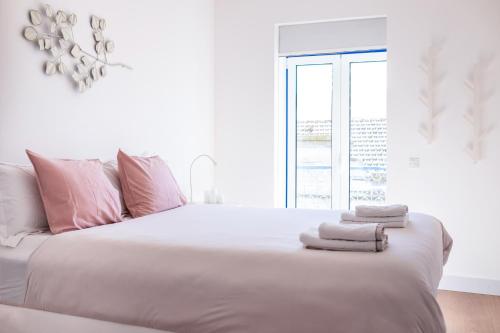 リスボンにあるLuxury Apartment near Cais do Sodréの白いベッドルーム(ピンクの枕が付いた大きな白いベッド付)