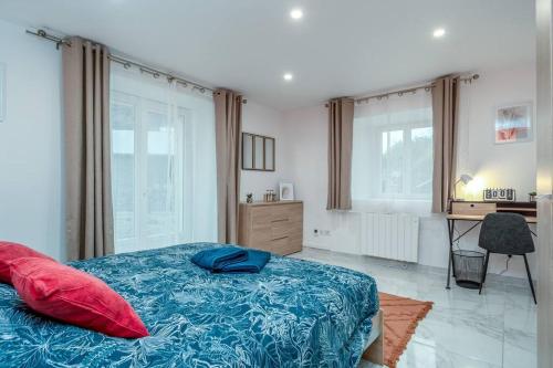 1 dormitorio con 1 cama con sábanas azules y almohadas rojas en L'écrin authentique, en Audincourt