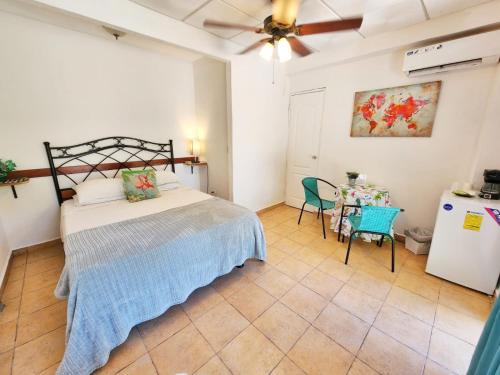 1 dormitorio con 1 cama y 1 mesa con sillas en Cerrito Tropical Eco Lodge, en Taboga