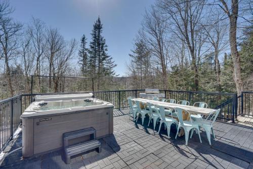 a hot tub and tables and chairs on a deck at Wilmington Chalet with Hot Tub Less Than 8 Mi to Mount Snow! in Wilmington
